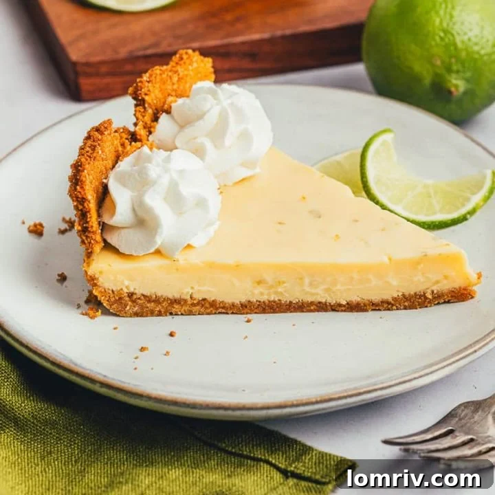 A perfect slice of Classic Key Lime Pie with whipped cream and a fork.