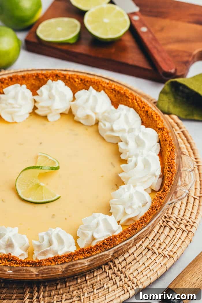 A close-up view of a Key Lime Pie, showing the vibrant green filling and a decorative lime slice.