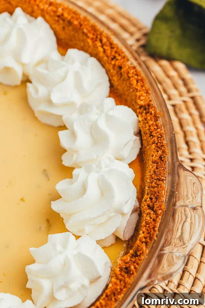 A close-up of a Key Lime Pie, adorned with swirls of freshly whipped cream, highlighting its inviting presentation.