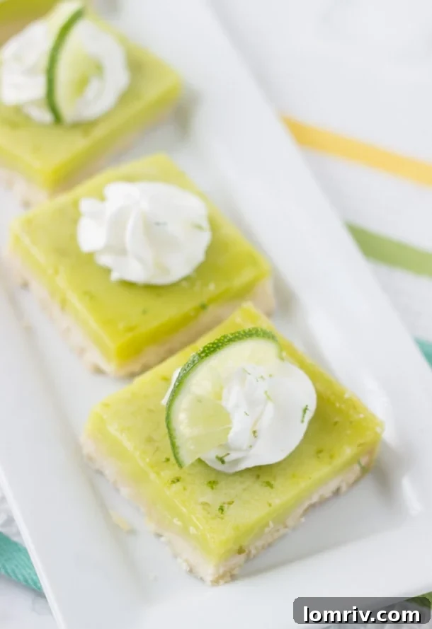 Close-up of a Coconut Lime Bar, revealing its perfectly golden shortbread crust and creamy lime filling, ready to be topped.