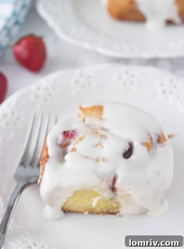 Delicious Strawberry Cinnamon Rolls - warm, juicy strawberries bursting in a buttery cinnamon swirl, topped with rich vanilla bean cream cheese frosting. The ultimate breakfast or brunch treat!