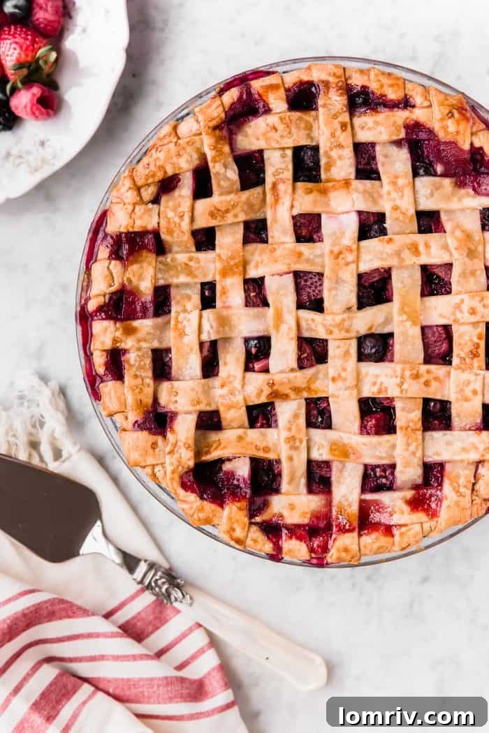 Close-up shot of a Mixed Berry Pie, highlighting the rich, bubbling berry filling under a perfectly golden crust.
