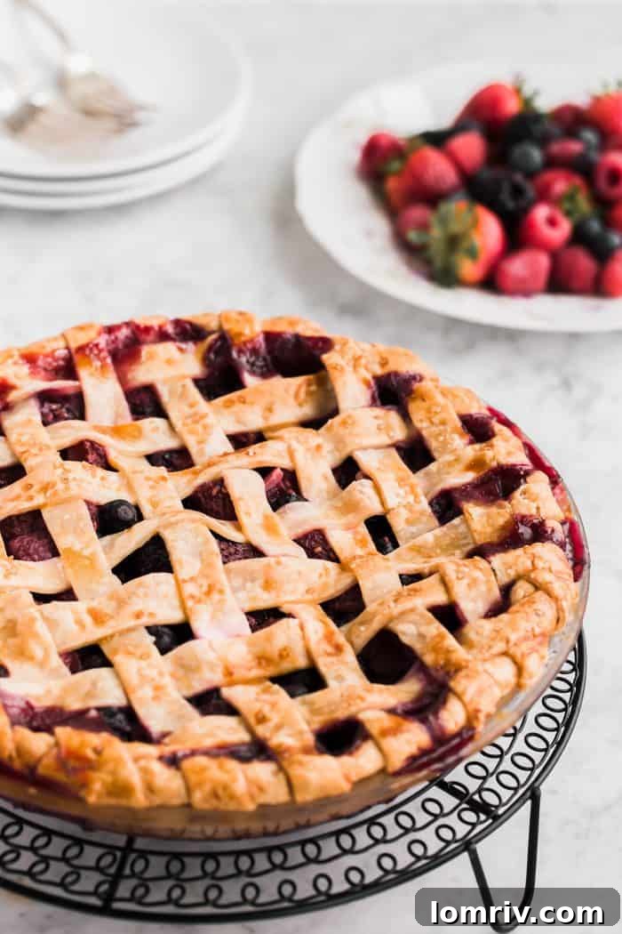 A slice of Mixed Berry Pie, showcasing the vibrant filling and tender crust, ready to be served.