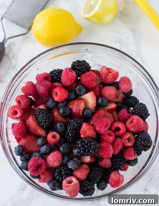 Close-up of fresh mixed berries ready for the pie filling, featuring vibrant reds and blues.