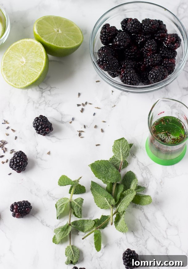 Two beautifully presented blackberry lavender cocktails, viewed from above, with fresh fruit and edible flowers, ready to be enjoyed
