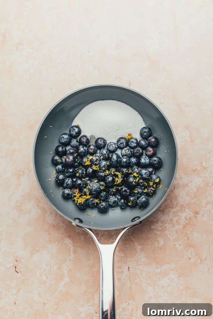 A saucepan filled with the ingredients to make blueberry compote.