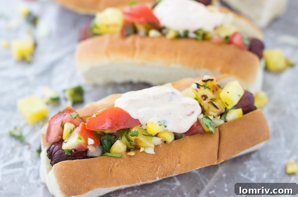 A vibrant spread of grilled ingredients for hot dogs, including corn, pineapple, and poblano pepper