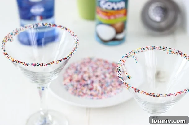 Close-up shot of a perfectly crafted Birthday Cake Martini, showing the creamy texture and colorful sprinkles adorning the rim of the glass. The drink has a rich, inviting appearance, promising a sweet and festive experience.