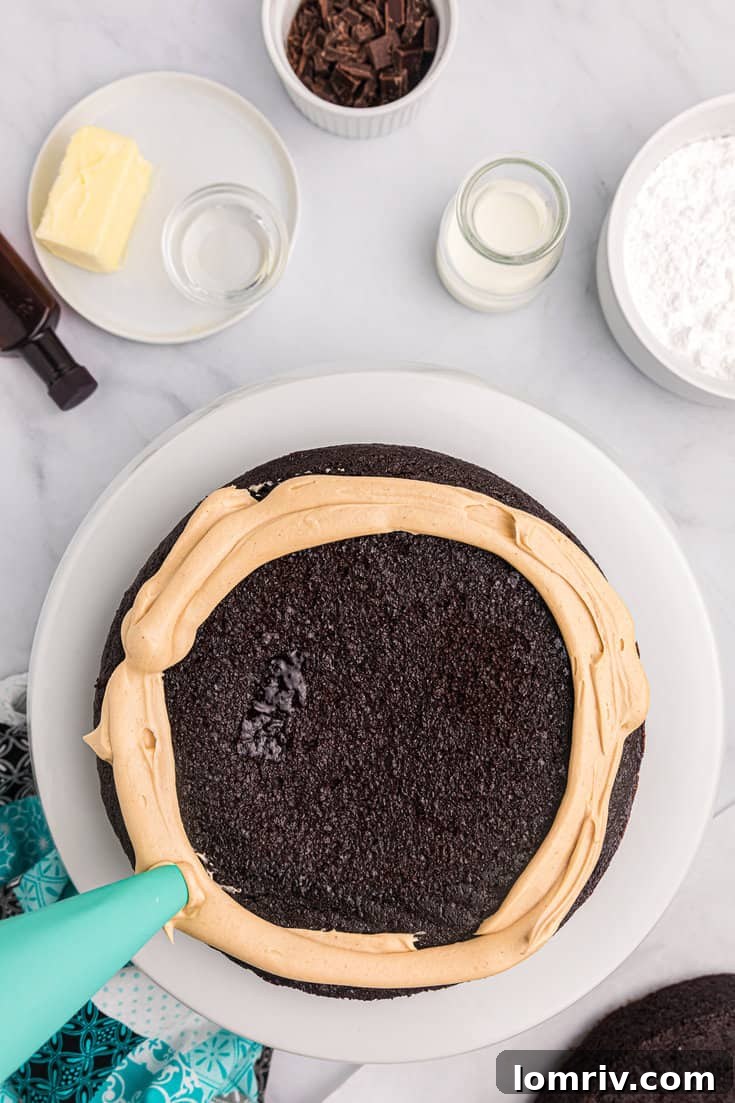 Adding peanut butter frosting to the chocolate cake layers.