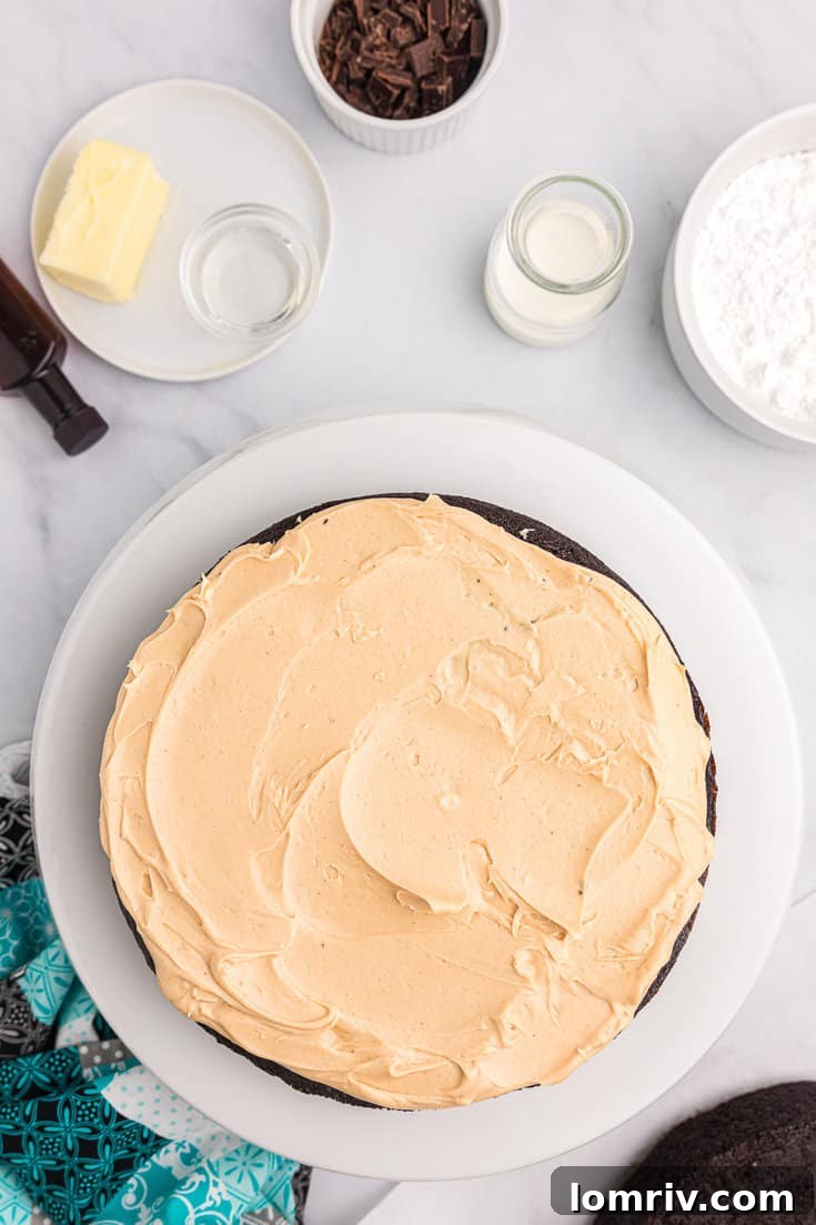 Smoothing peanut butter frosting on the chocolate cake.