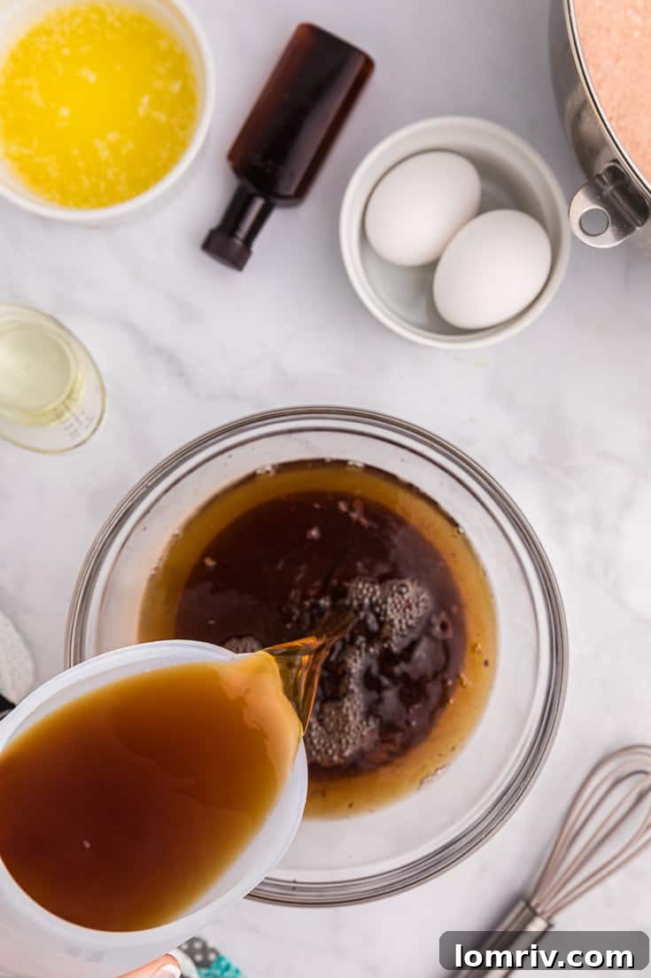 Adding hot coffee to wet ingredients.
