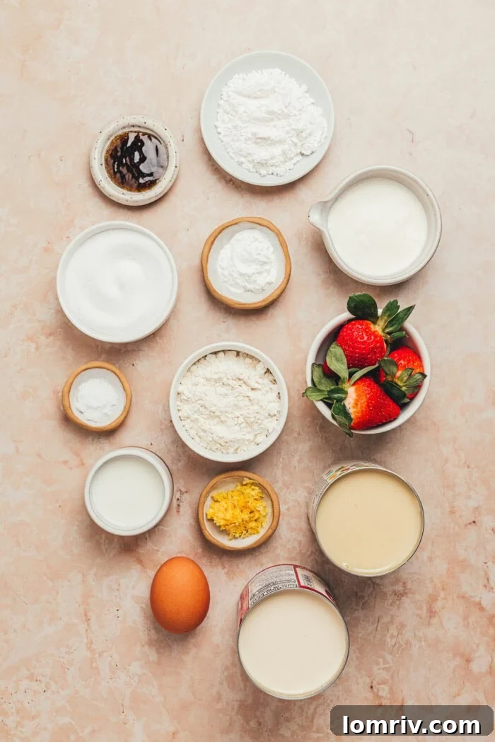A collection of ingredients laid out, including flour, eggs, milk, strawberries, and other baking essentials for the tres leches cake.