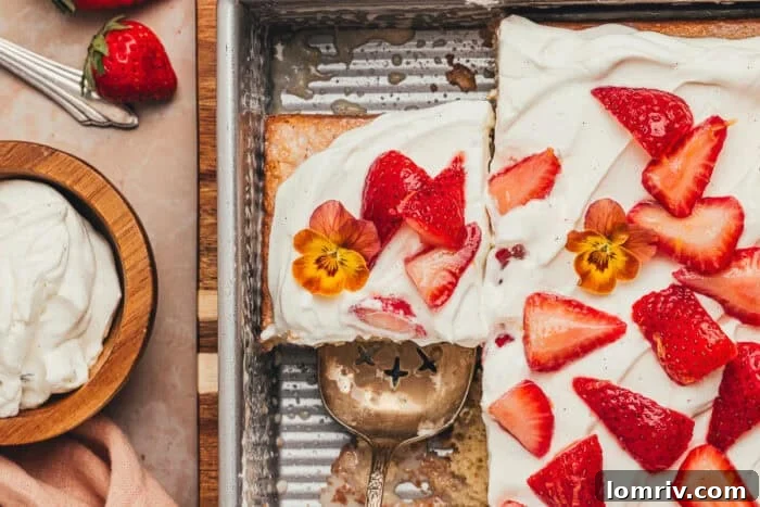 A cake pan with several slices of strawberry tres leches cake remaining, covered for storage.