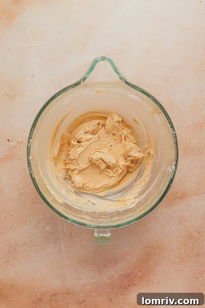 The finished smooth and creamy espresso buttercream in a glass mixing bowl.