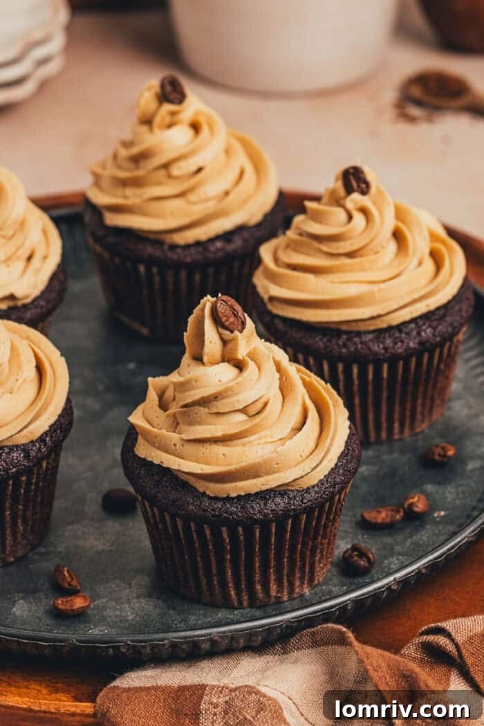 Two chocolate cupcakes with espresso buttercream frosting arranged on a decorative platter.