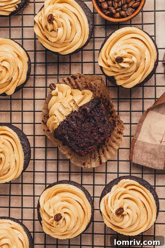 A chocolate espresso cupcake on its side with a bite taken out, showing the moist interior crumb.