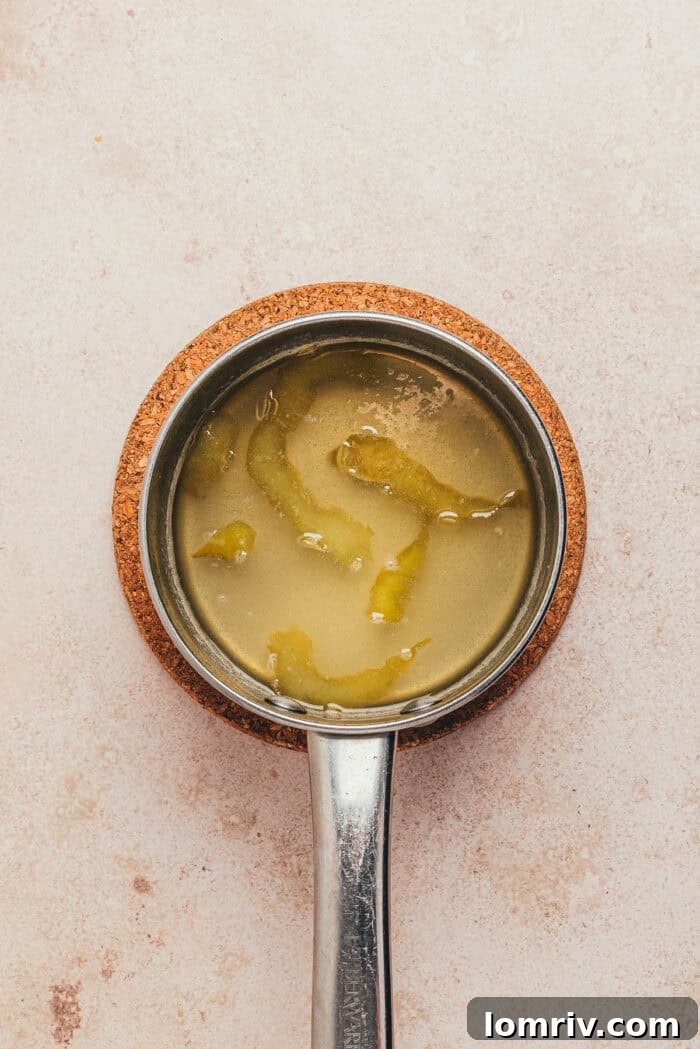 The ingredients to make the lemon syrup in a saucepan.