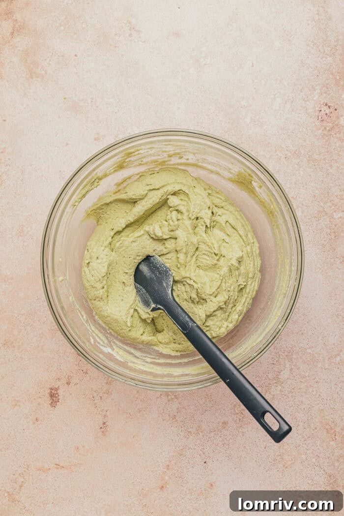 A glass bowl with the whipped cream and pistachio mascarpone combined.