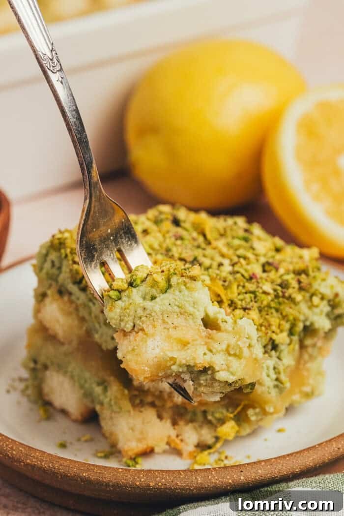 A fork taking a bite of out a slice of tiramisu on a plate.