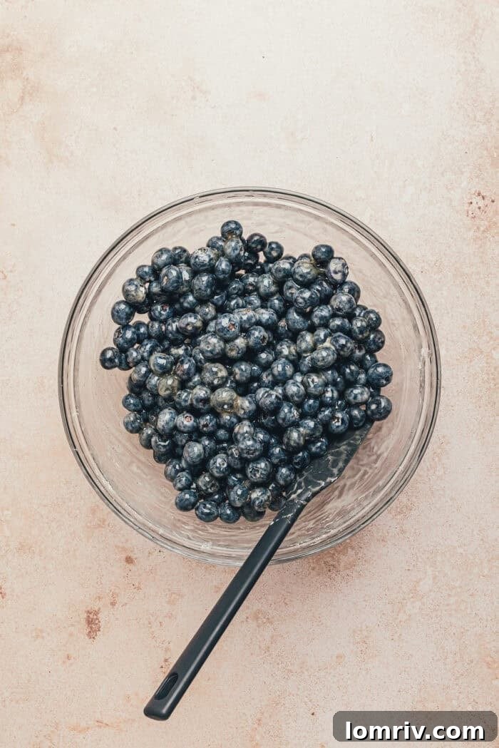 Honey-Sweetened Blueberry Cobbler Recipe with Fresh Berries 10 Blueberries in a bowl with a spatula.
